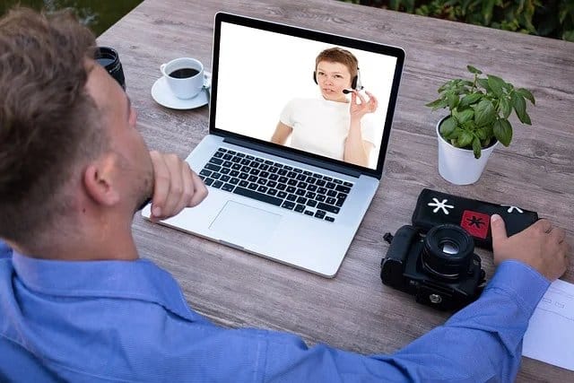 aluno estudando inglês no notebook e conversando com professor em videochamada